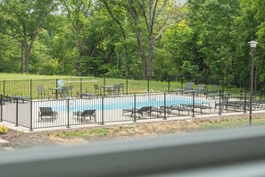 A swimming pool with a metal fence, surrounded by trees and outdoor seating. - Panoramic Table Rock Lake Views, Shared Outdoor Pool, Air Hockey, Free Tickets (Branson)