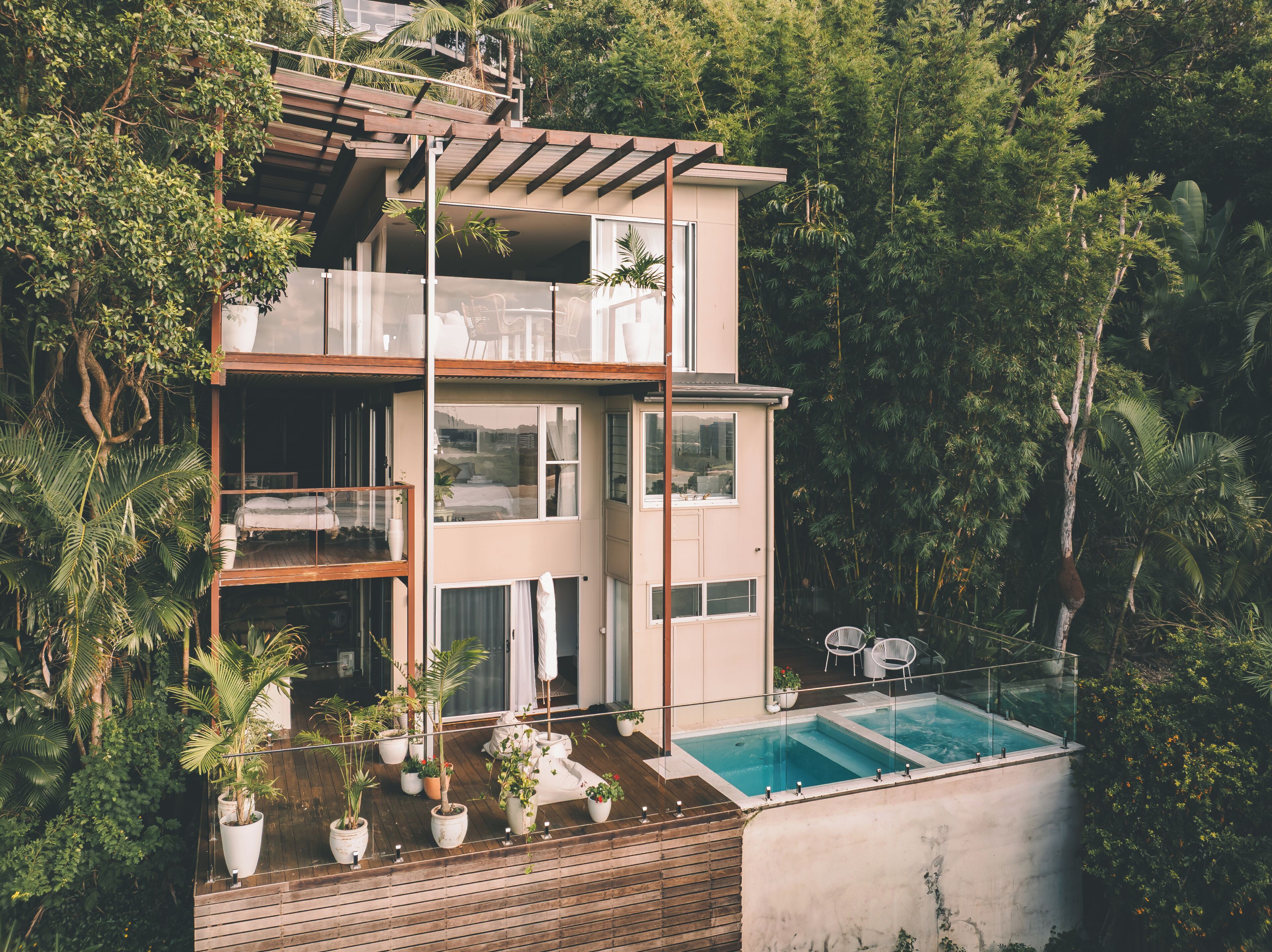 Una moderna casa a più piani con piscina, immersa nel verde.