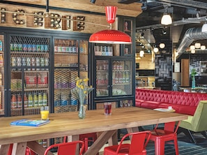 A restaurant interior with a wooden bar, red seating, and a decorative sign above the bar. - Eklo Hotels Paris Roissy CDG Airport (Roissy-en-France)