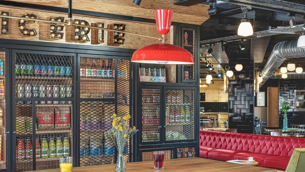 A restaurant interior with a wooden bar, red seating, and a decorative sign above the bar. - Eklo Hotels Paris Roissy CDG Airport (Roissy-en-France)