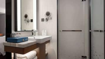 A modern bathroom with a sink, mirror, and a glass shower enclosure.