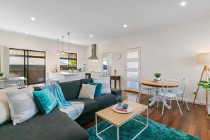 Relax in this stylish living space with a sofa, coffee table, and dining area.
