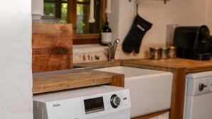 Eine kompakte, moderne Küche mit integriertem Waschtrockner, Holz Arbeitsplatten und einem Fenster mit Blick.