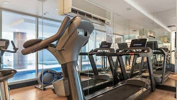 A gym with treadmills, stationary bikes, and a rowing machine.