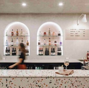 Eine Bar mit Regalen voller Spirituosenflaschen, einer Speisekarte und einer Bar.