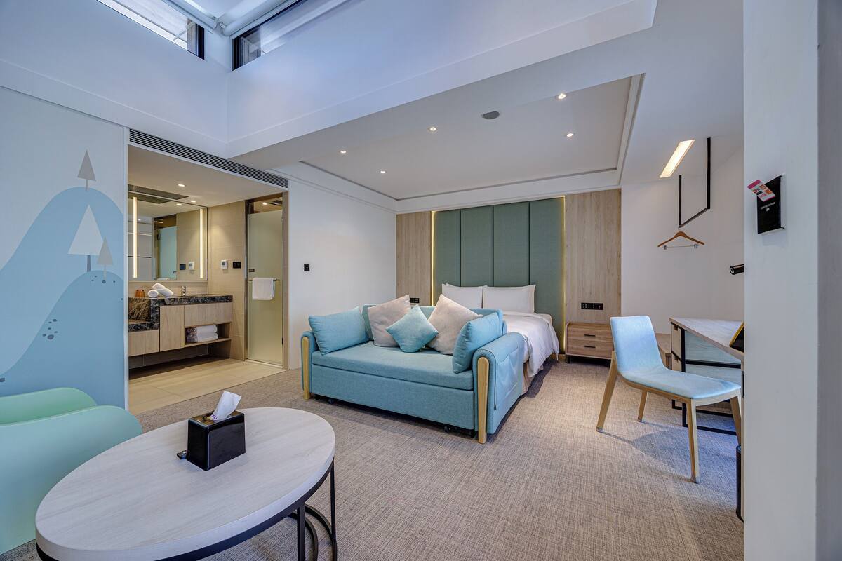 Une chambre d’hôtel moderne équipée d’un canapé, d’un lit, d’un bureau et d’une chaise.