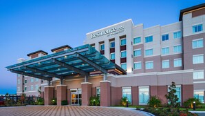 Un hôtel à plusieurs étages doté d’une entrée couverte et d’une enseigne indiquant « Residence Inn by Marriott ».