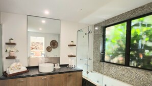 A modern bathroom with a large mirror, a round sink, and a glass-enclosed shower. - Luxury Spa Suite #220 Temple Palm Cove (Palm Cove)