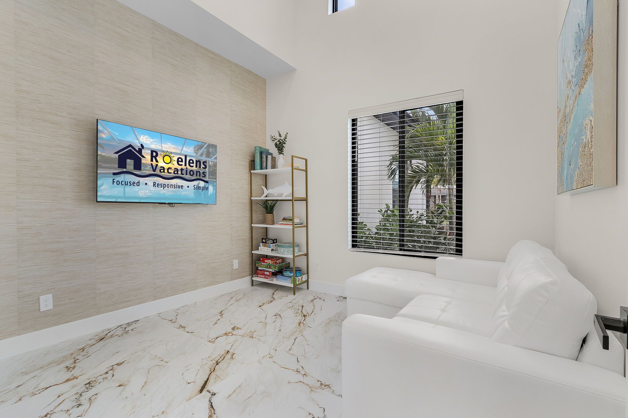 A modern living room with a white sofa, a bookshelf, and a TV displaying 'Roelens Vacations'.