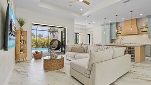Un salon spacieux avec un grand canapé, une table basse et une vue sur une piscine.