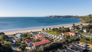 A coastal residential area with houses, a beach, and a clear view of the ocean.