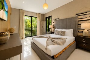 A modern bedroom with a large bed, a nightstand, a lamp, and a view of greenery outside. - Villa Sole Luxury Retreat – Upper East Miami (Miami)