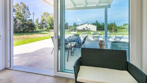 Ein stilvolles Zimmer mit einer Schiebetür zu einer Außenpatio-Terrasse mit Pool und Liegestühlen.