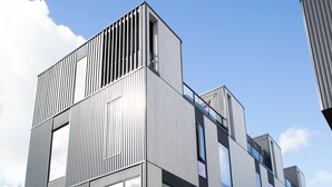 En modern byggnad med flera våningar, stora fönster och ett platt tak.