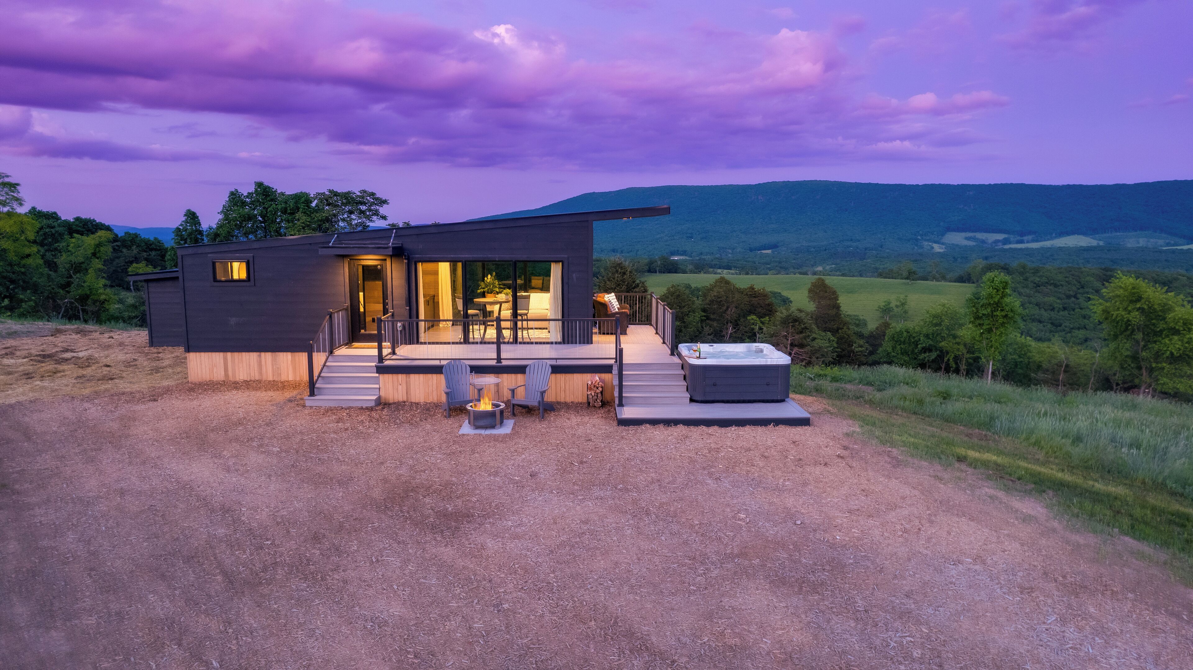 Una casa moderna con terraza, mobiliario exterior y jacuzzi.