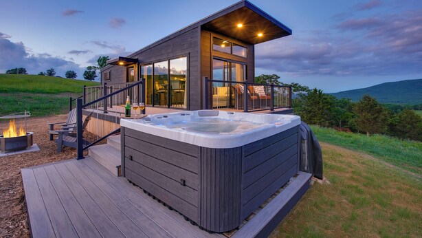 A modern house with a hot tub, deck, and a fire pit. - Hart's Overlook | Hot Tub, Stunning Mtn Views + Private Pond! (Augusta)