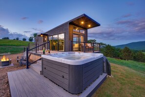 A modern house with a hot tub, deck, and a fire pit. - Hart's Overlook | Hot Tub, Stunning Mtn Views + Private Pond! (Augusta)