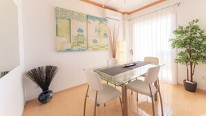 A dining area with a glass table, four chairs, and two paintings on the wall. - Casa Turquesa by Solset (Torrox)