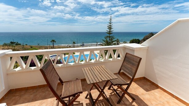 A balcony with a view of the ocean, a pool, and a white railing. - Casa Turquesa by Solset (Torrox)