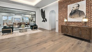 A modern interior with a brick accent wall, a large portrait, and a contemporary seating area. - The Flying Fifty, a Luxury Boutique Hotel (Cullman)