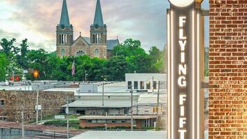 A hotel sign with a clock and a flying fifty sign.