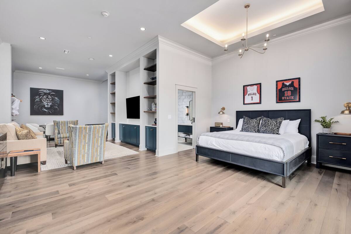 A modern bedroom with a large bed, a TV, and a wardrobe.