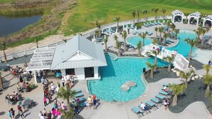 A resort with multiple swimming pools, outdoor seating areas, and a golf course in the background. - Newly built oceanfront home with elevator, balconies, and awe-inspiring views (Port Aransas)
