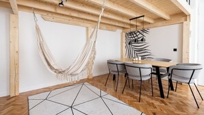 A dining area with a wooden ceiling, a hammock, and a geometric rug. - Old Town Apartment with Mezzanine (Kraków)