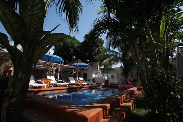 Piscina a l'aire lliure, para-sols i gandules