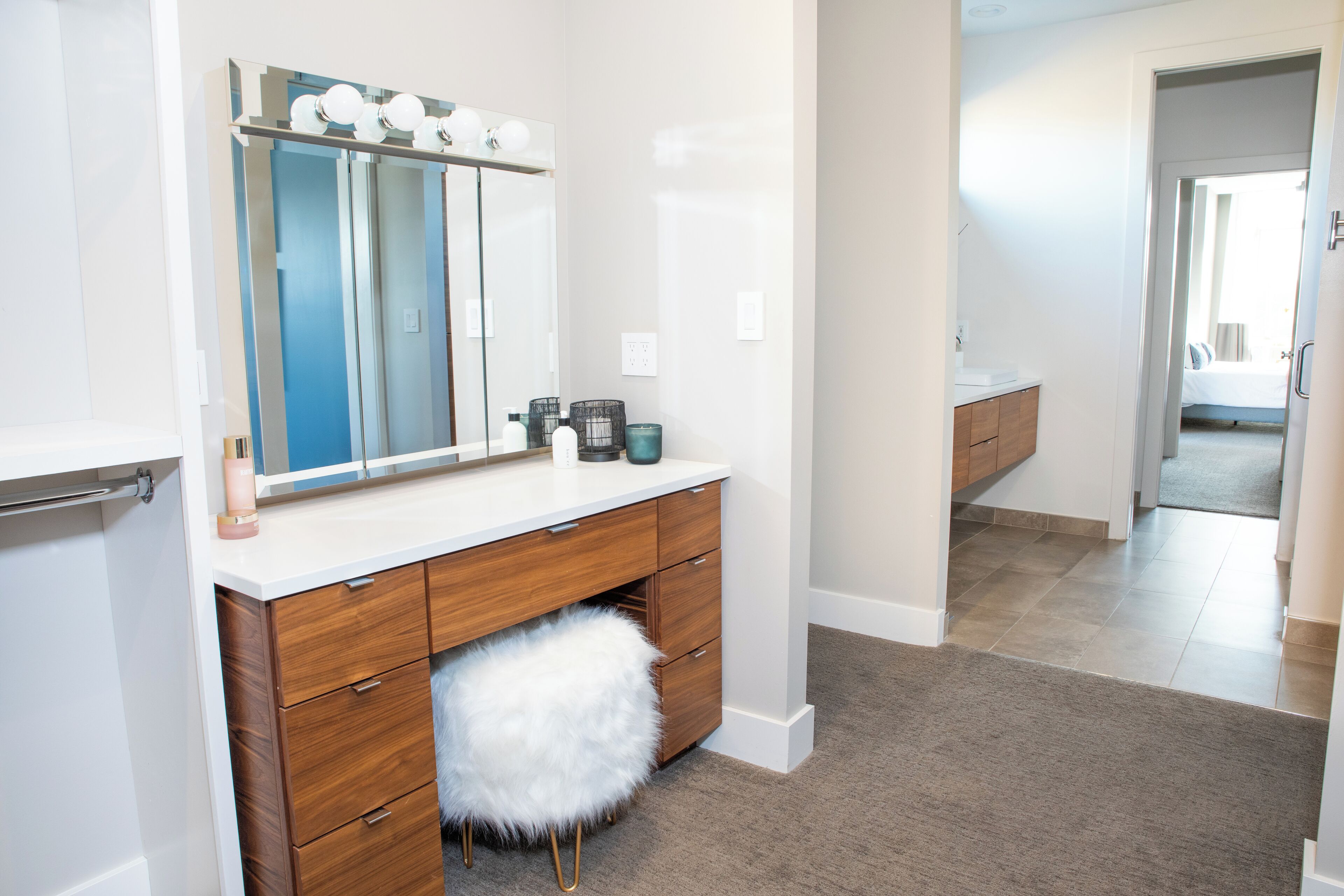 A modern bathroom with a vanity, mirror, and toiletries.