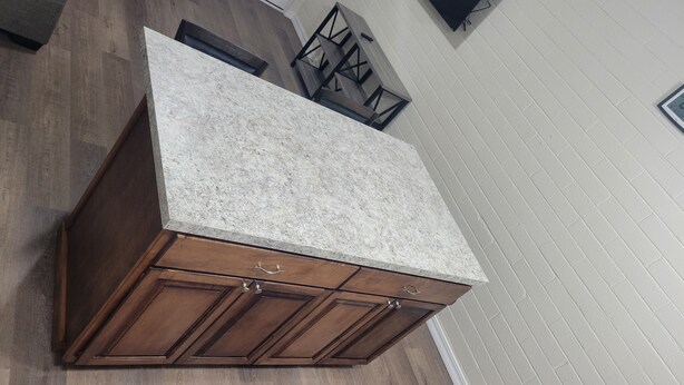 A kitchen with a granite countertop and wooden cabinets.