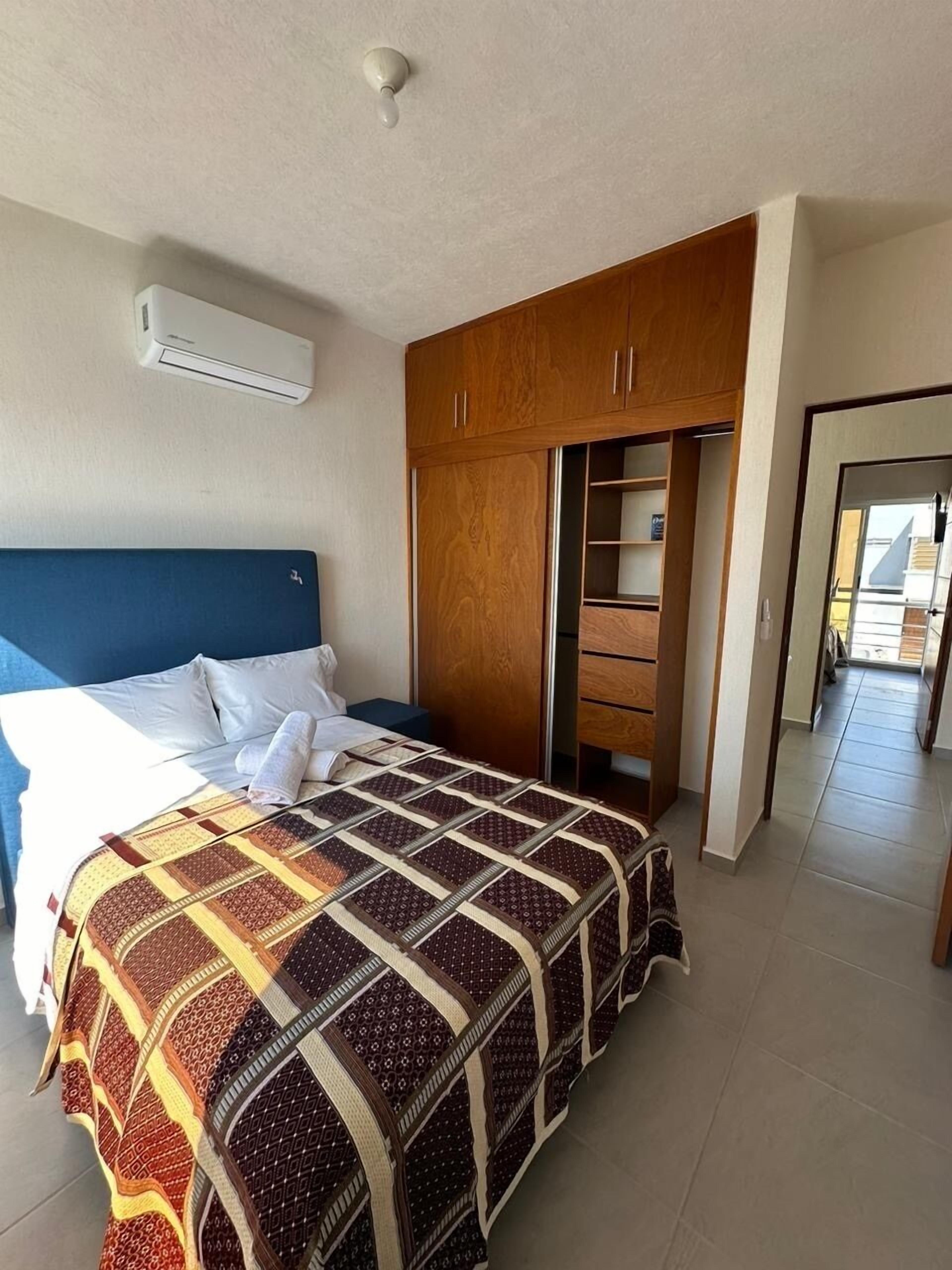 A bedroom with a bed, a wardrobe, and a walk-in closet.