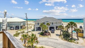 Une propriété située en bord de mer, dotée de plusieurs garages, d’une piscine et offrant une vue sur l’océan.