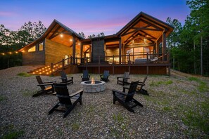 Eine Blockhütte mit einer Terrasse, Sitzgelegenheiten im Freien und einer Feuerstelle.