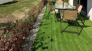 A patio with a table and chairs, a pool, and a well-maintained lawn. - Puerto Vallarta Altavela Egina 62 (Valle de Banderas)