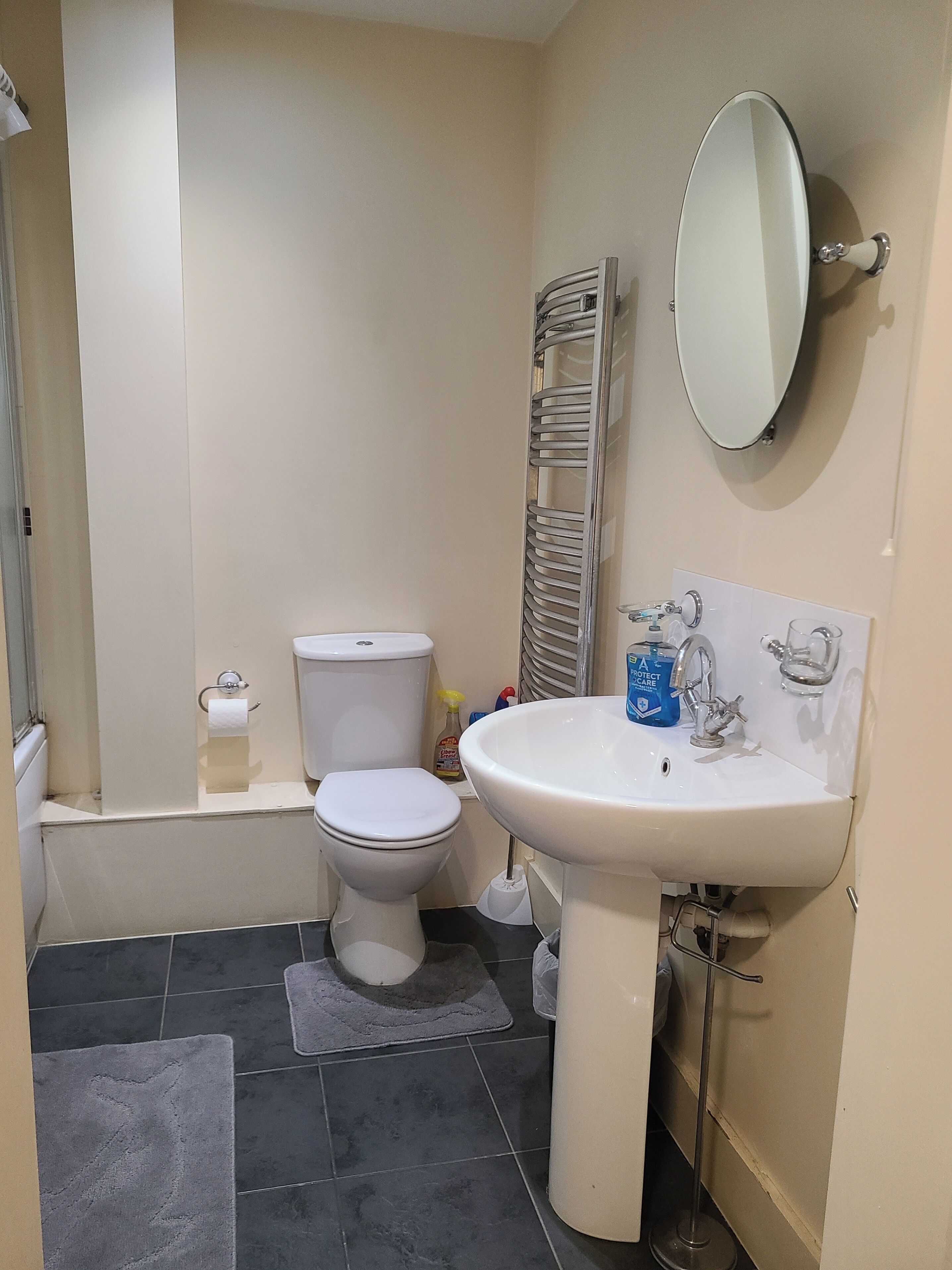Un baño pequeño con inodoro, lavabo, espejo y toallero.