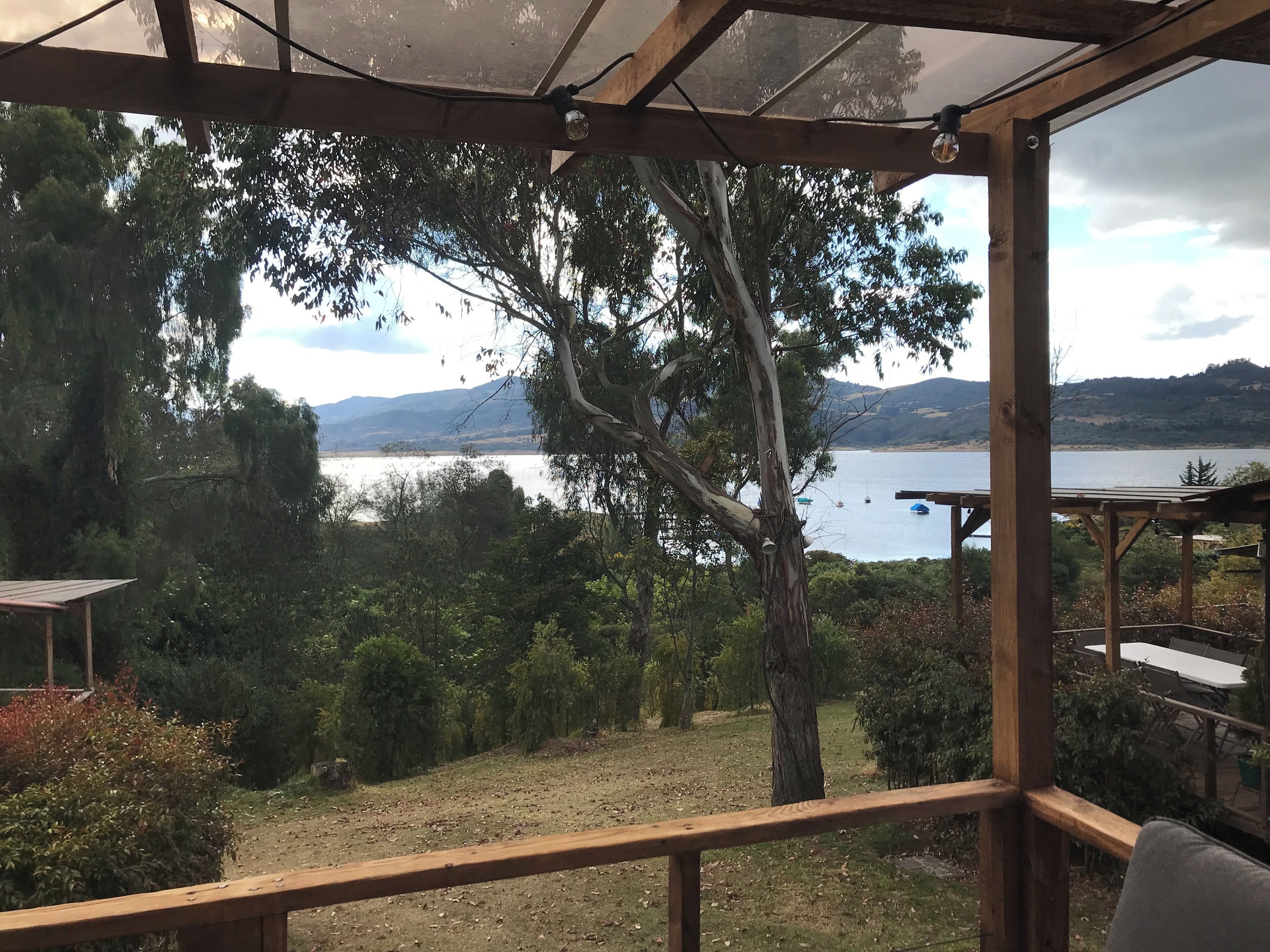 A wooden deck with a view of a lake and hills.