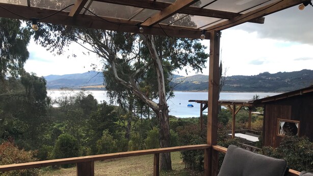 Um deck de madeira com vista para um lago e montanhas.
