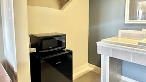 A compact kitchen with a microwave, a sink, and a small countertop. - Regency Inn Fresno (Fresno)
