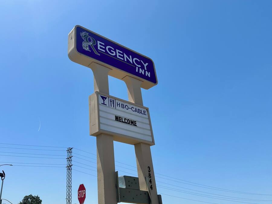 Schild für 'EGENCY INN' mit der Aufschrift 'WILLKOMMEN' und dem Symbol für 'HBO-CABLE'.