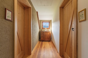 A narrow hallway with wooden doors and a window at the end. - Suite Alder embraced by nature, Slovenj Gradec, Slovenia (Slovenj Gradec)