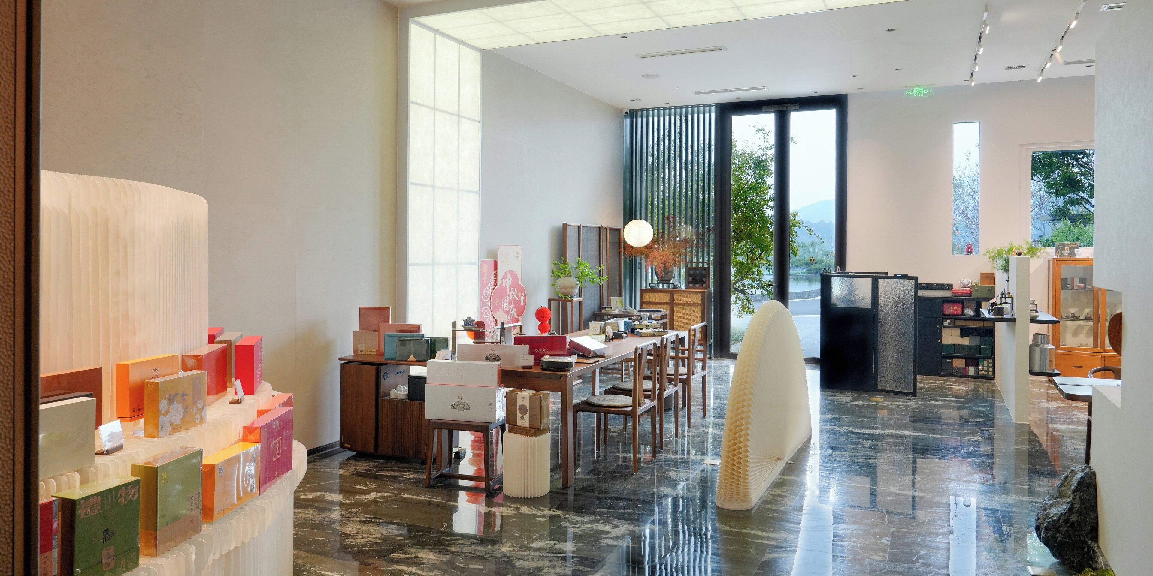 Un hall d’hôtel spacieux au design moderne, comprenant un grand espace de restauration, un comptoir d’accueil et une vue sur l’extérieur.