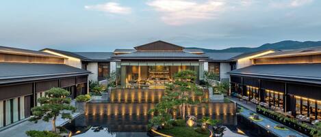 A modern hotel with a central courtyard, reflecting pool, and traditional architecture.