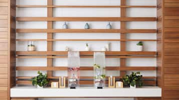 Una estantería de madera con varios compartimentos, algunos con objetos decorativos y otros con recipientes transparentes que contienen plantas.