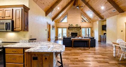 Riverfront cabin with private dock, firepit, wraparound porch & fireplace