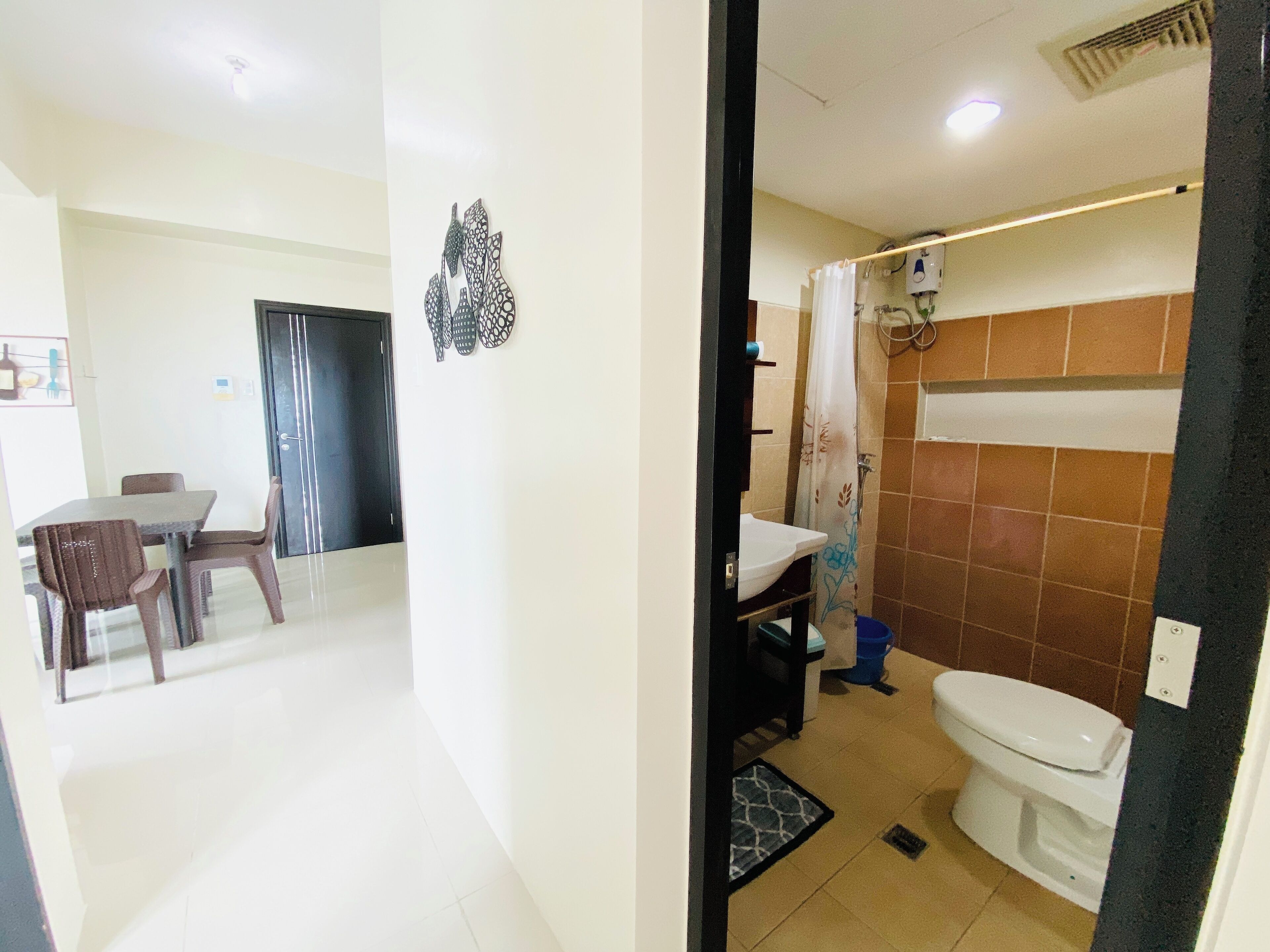 A room with a dining area, a shower, and a toilet.