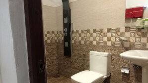 A bathroom with a toilet, bidet, and sink. - solitary resort  (Ella)