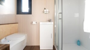 A bathroom with a toilet, sink, and shower area.
