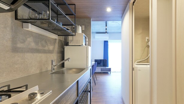 A modern kitchen with a stainless steel countertop, a built-in microwave, and a dishwasher. - MATSUMIZAKA HILL by Tranova (Tokyo)