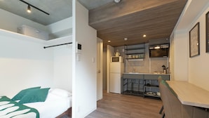 A compact living space with a bed, kitchenette, and a small dining area. - MATSUMIZAKA HILL by Tranova (Tokyo)